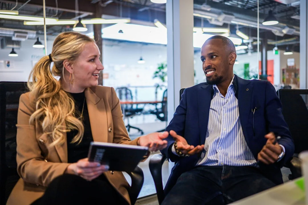 Team members discussing digital graphs on a tablet in a modern office setting.